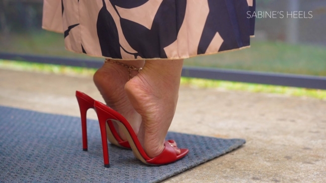 RED SHARLENE MULES DANGLING UNDER THE TABLE